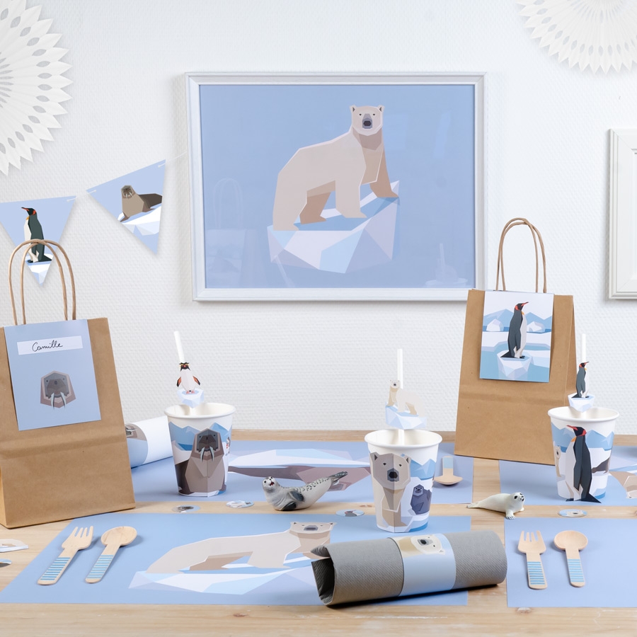 Conjunto de festa infantil temático de animais polares com artigos em azul, branco e castanho claro numa mesa de madeira