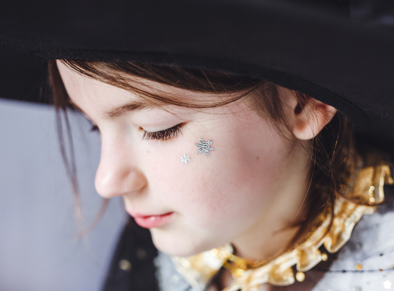 Rapaz com chapéu preto e adesivos prateados na cara