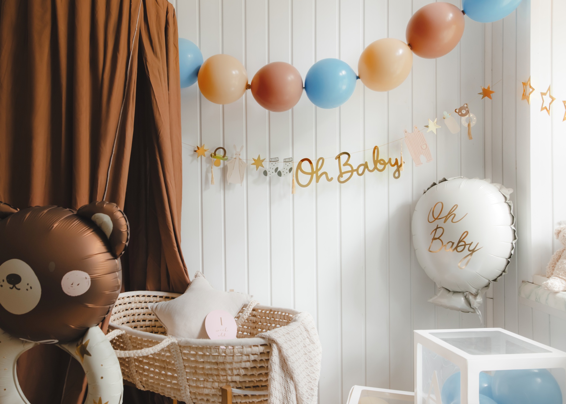 Decoração festa bebé com balões, móbile Oh Baby, berço de vime e almofada estrela