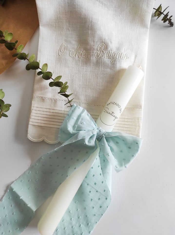 Toalha branca bordada e vela de batismo com laço azul claro