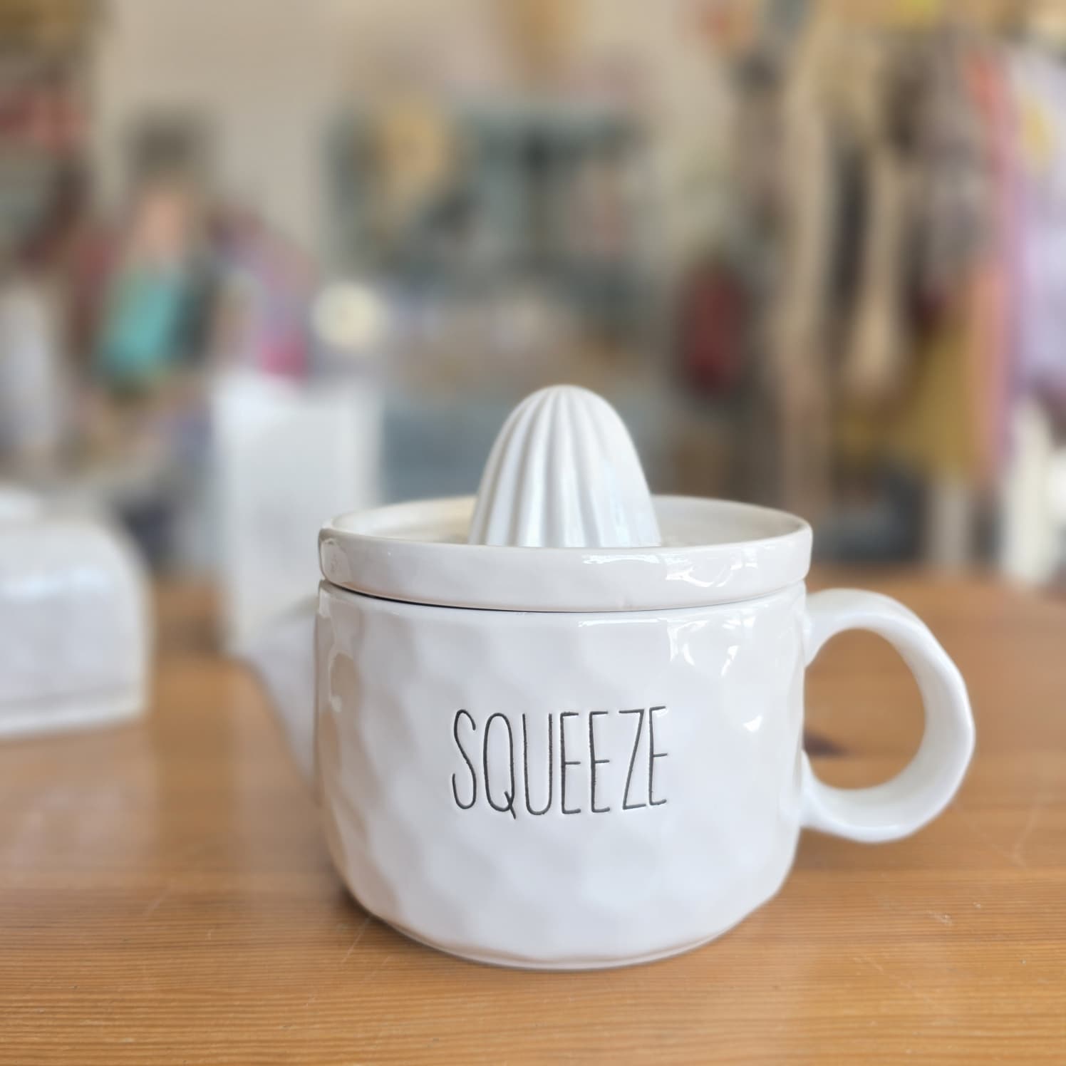 Espremedor de sumo branco em cerâmica com a palavra SQUEEZE