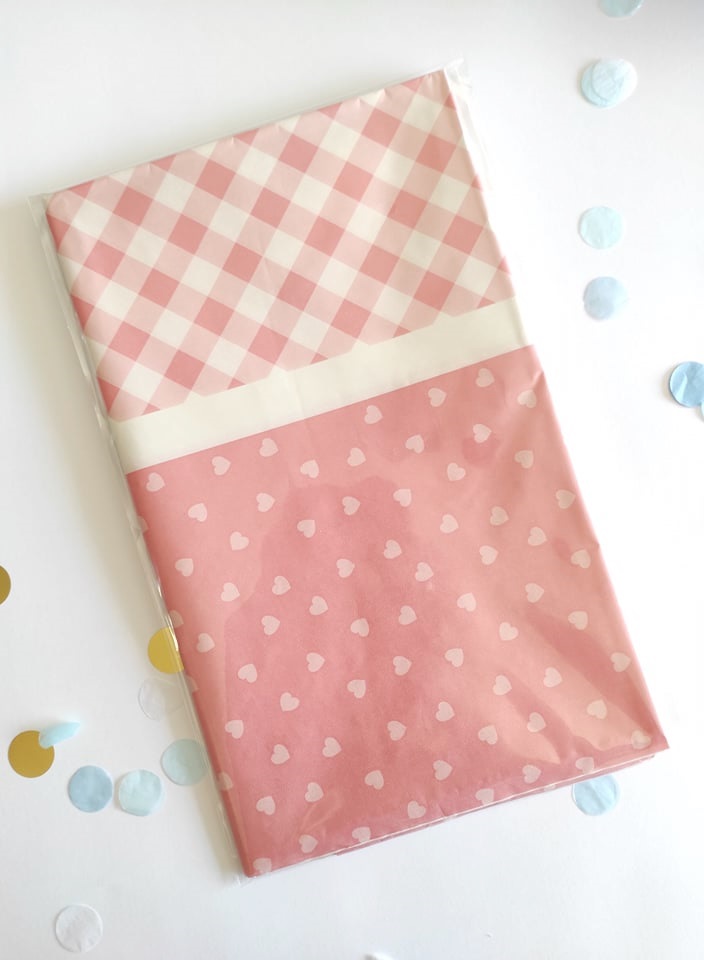 Toalha de mesa rosa com padrões xadrez e corações embalada em plástico
