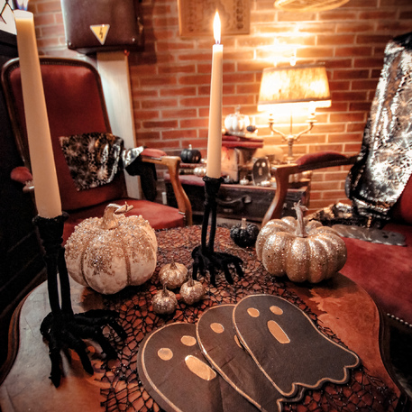 Mesa com decoração de Halloween e cadeiras em sala aconchegante