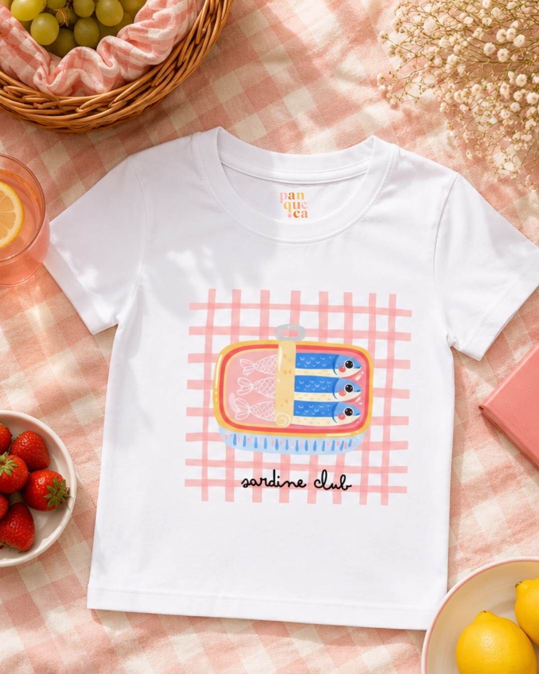 Camiseta branca com estampa de lata de sardinha e padrão xadrez rosa