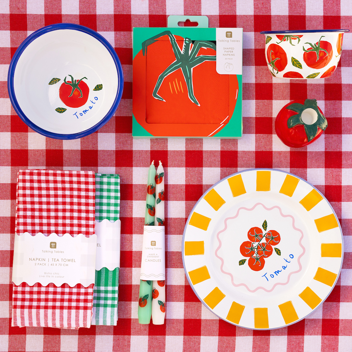 Conjunto de produtos de cozinha e decoração com tema de tomate numa toalha xadrez vermelha e branca