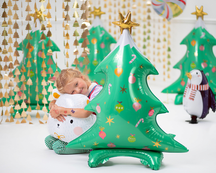 Balões de árvore de Natal verde e pinguim decorativo num ambiente festivo branco com correntes douradas