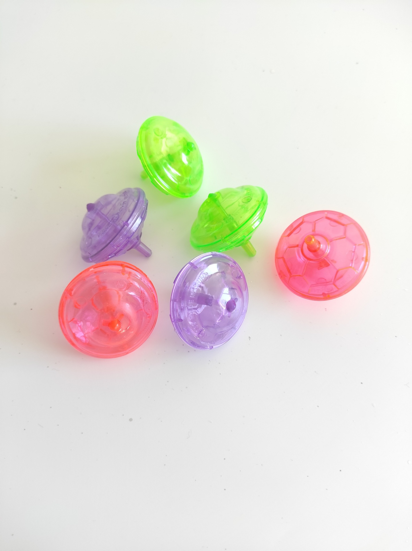 Seis peões coloridos em plástico translúcido sobre fundo branco