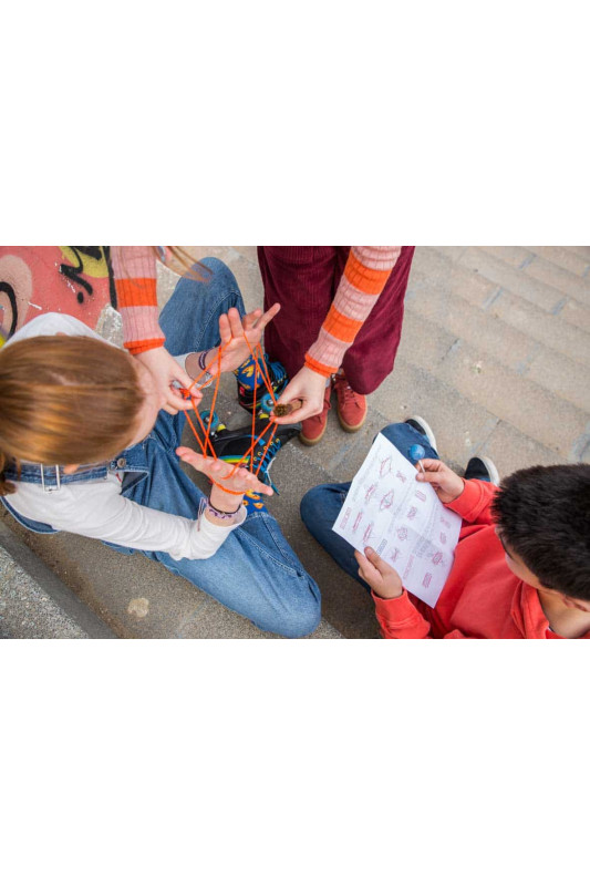 Crianças a jogar com fios laranja em espaço urbano