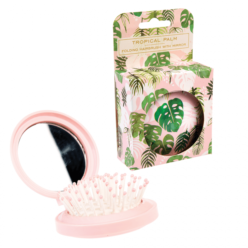 Escova de cabelo dobrável rosa com espelho e embalagem decorada com folhas tropicais