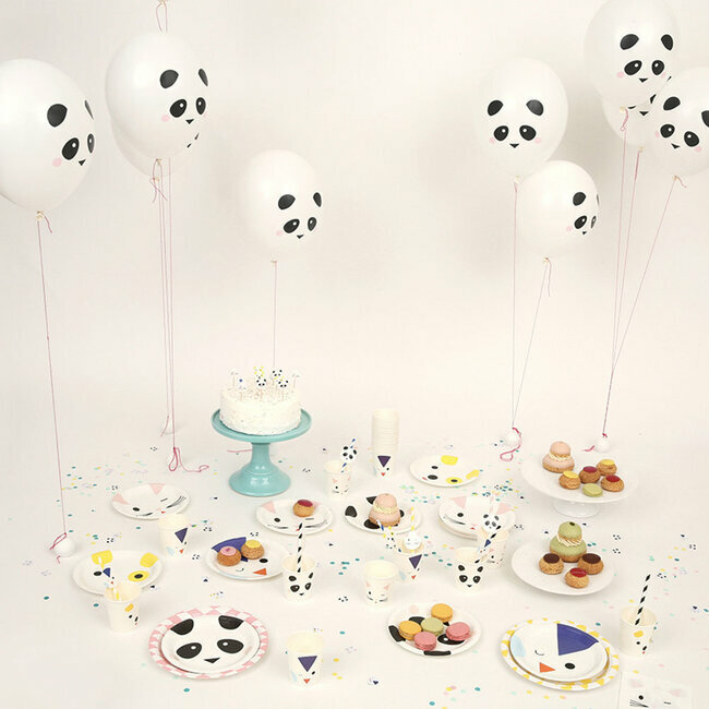 Artigos para festa infantil com tema de panda incluindo balões e pratos com padrão panda, bolo branco e macarrons coloridos.
