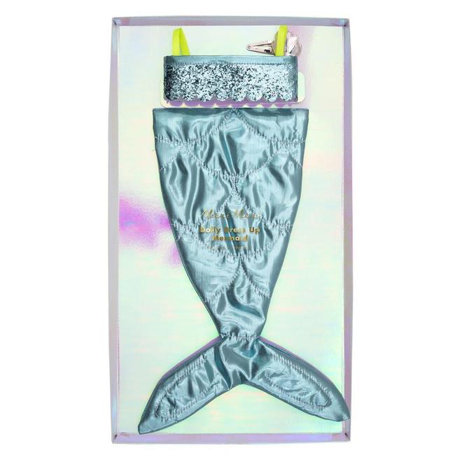 Conjunto com capa de sereia azul brilhante e diadema com laço preto e branco em caixa lilás.