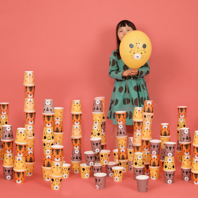 Copos de papel coloridos com desenhos de animais empilhados e criança com balão amarelo com cara de animal