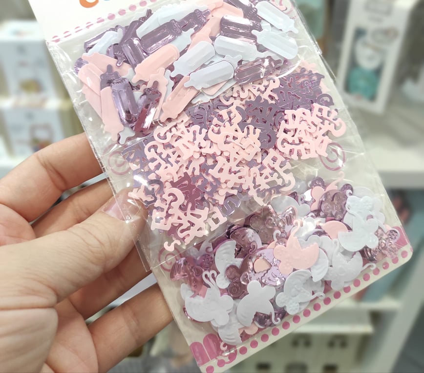 Pacote com confetes coloridos em formas diversas, embalados em plástico transparente.