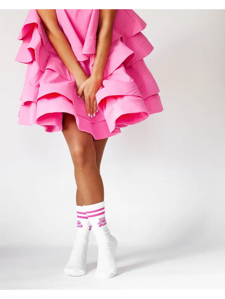 Vestido rosa com várias camadas e meias brancas com riscas e texto cor-de-rosa