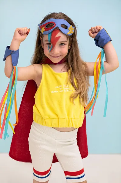 Criança fantasiada de super-herói com capa vermelha e máscara azul