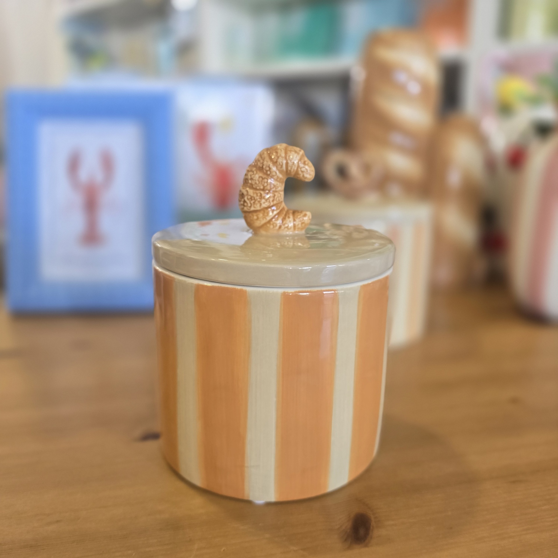 Pote de cerâmica às riscas com tampa e puxador em forma de croissant