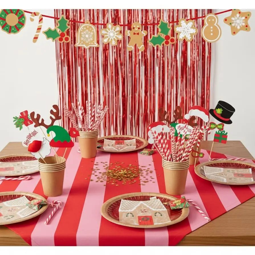 Mesa de Natal decorada com pratos, copos, canudos e acessórios festivos em vermelho, rosa e motivos natalícios.