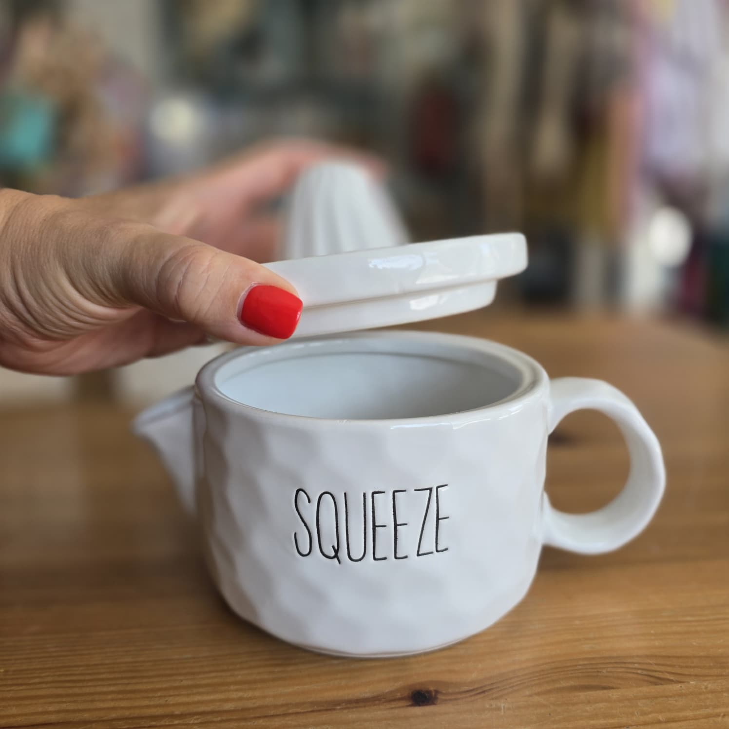 Espremedor de citrinos em cerâmica branca com texto SQUEEZE