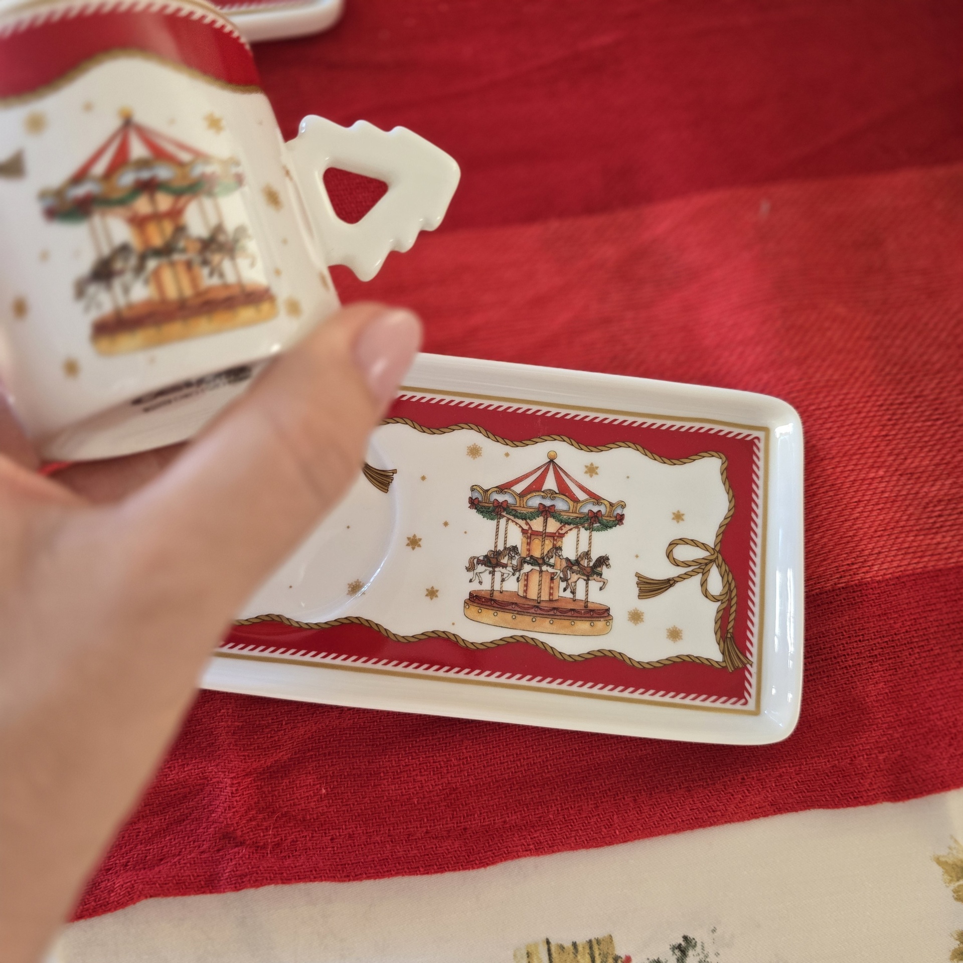Caneca e prato de porcelana com desenho de carrossel colorido e detalhes dourados e vermelhos