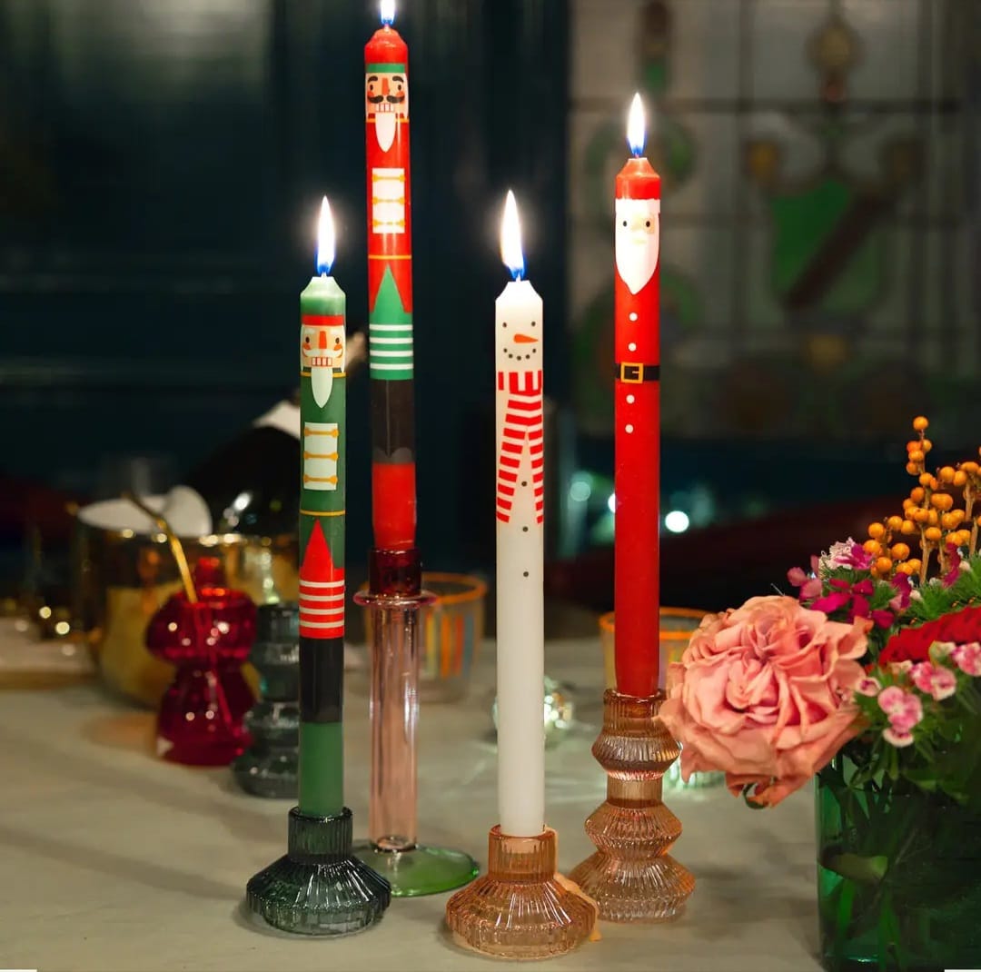 Velas decorativas natalícias acesas em castiçais de vidro