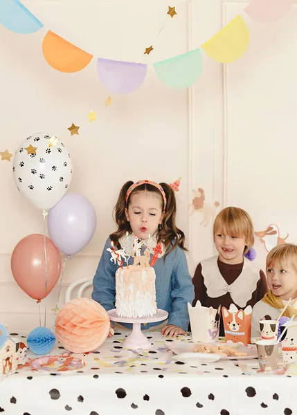Festa de aniversário infantil com decoração colorida e bolo branco na mesa