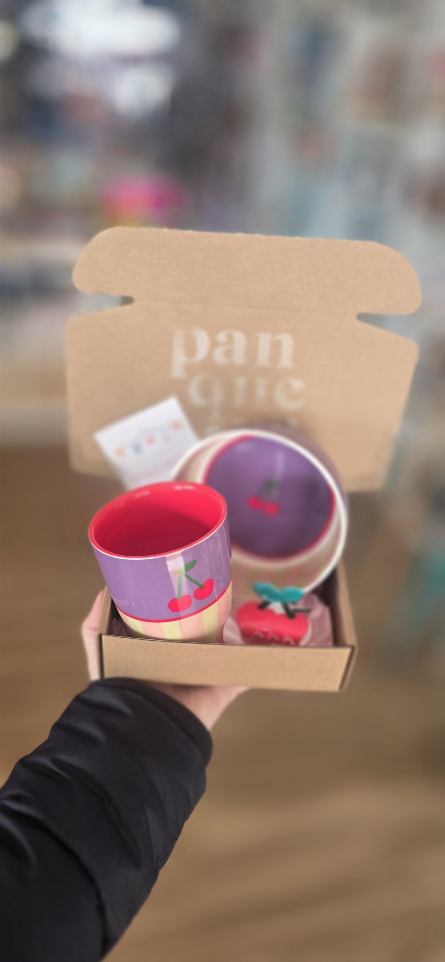 Conjunto cerâmico com copo e prato decorados com cerejas dentro de caixa de cartão