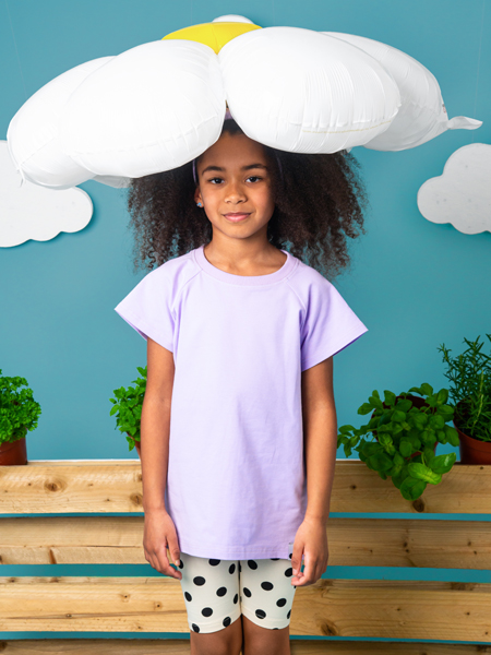 Criança com camisola lilás e leggings com bolinhas pretas, com balão de nuvem branca