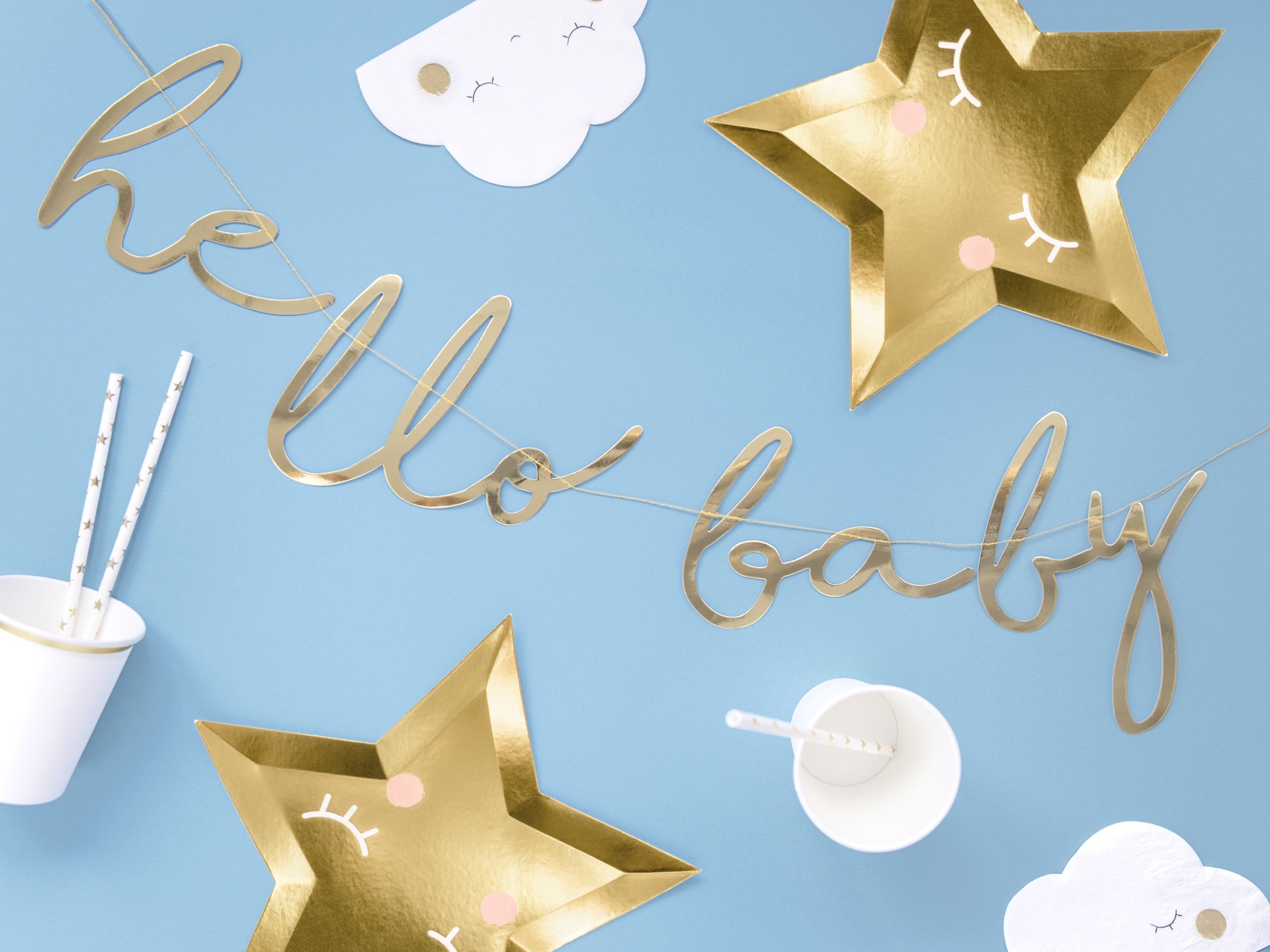 Decoração de festa com tema baby com estrela dourada, nuvens brancas, copos e palhinhas e frase hello baby em dourado