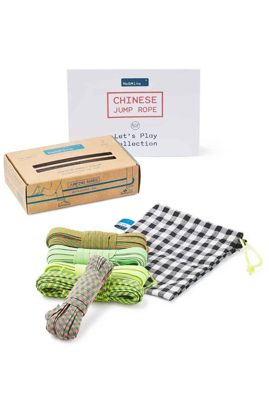 Cordas para saltar coloridas e saco de tecido em preto e branco junto à embalagem de cartão