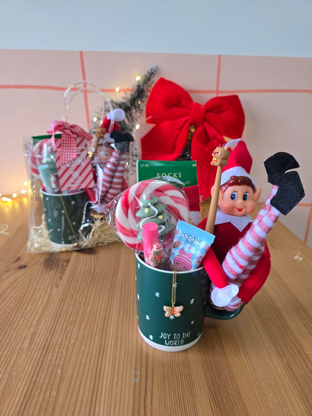 Caneca verde decorativa com texto Joy to the World com elfo e produtos de Natal no interior