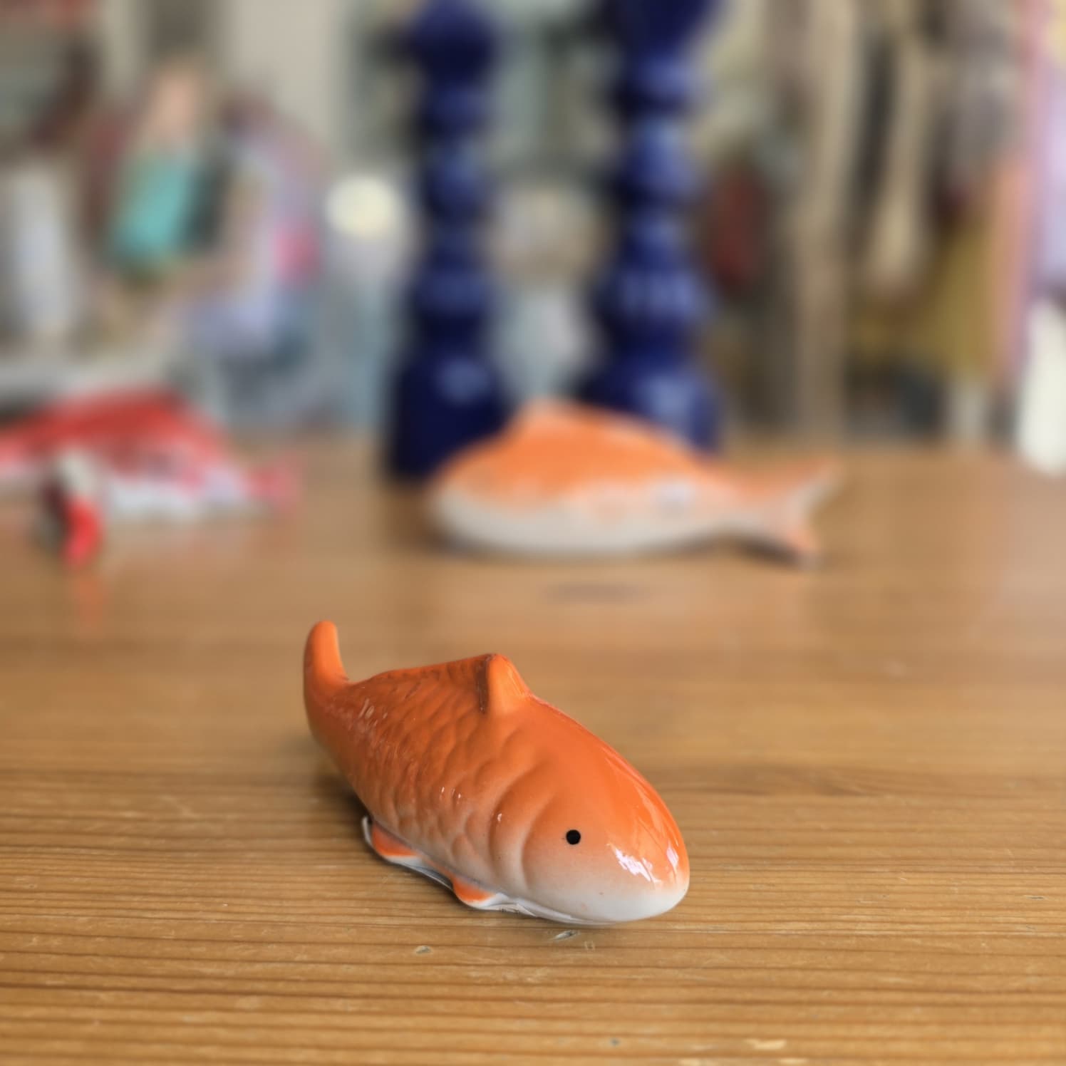Figura de tubarão laranja e branco em superfície de madeira