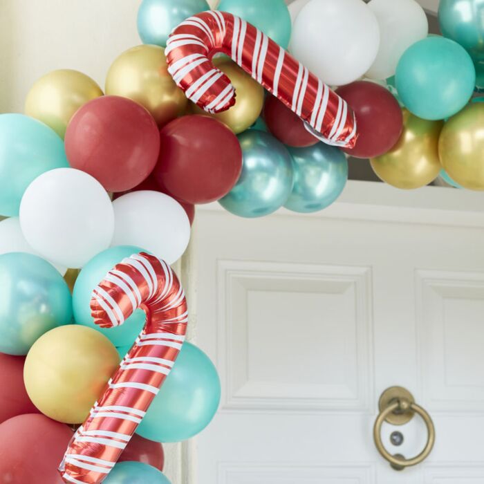 Balões de festa em várias cores e formas decorando a entrada de uma porta branca