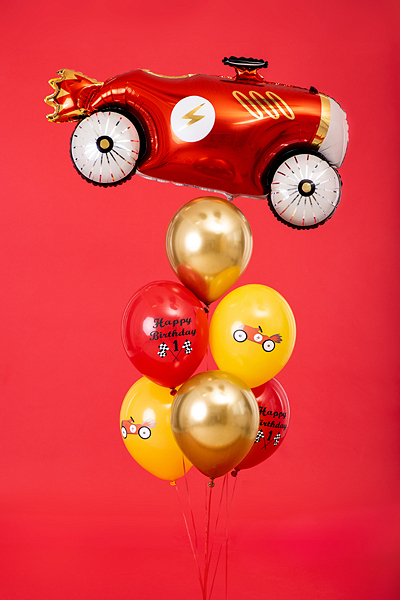 Balões de festa com tema de carro de corrida, em vermelho, dourado e amarelo, com texto e desenhos, fundo vermelho.