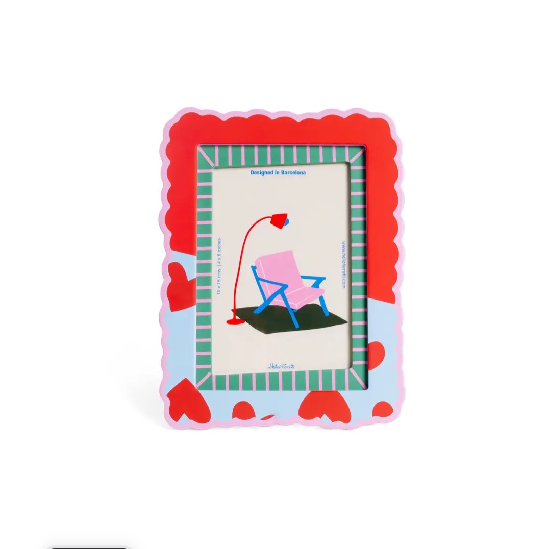 Moldura decorativa colorida com padrão ondulado e corações vermelhos, com ilustração de cadeira rosa e candeeiro.