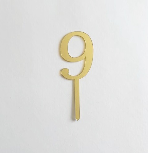 Número 9 dourado decorativo com haste inferior sobre fundo branco