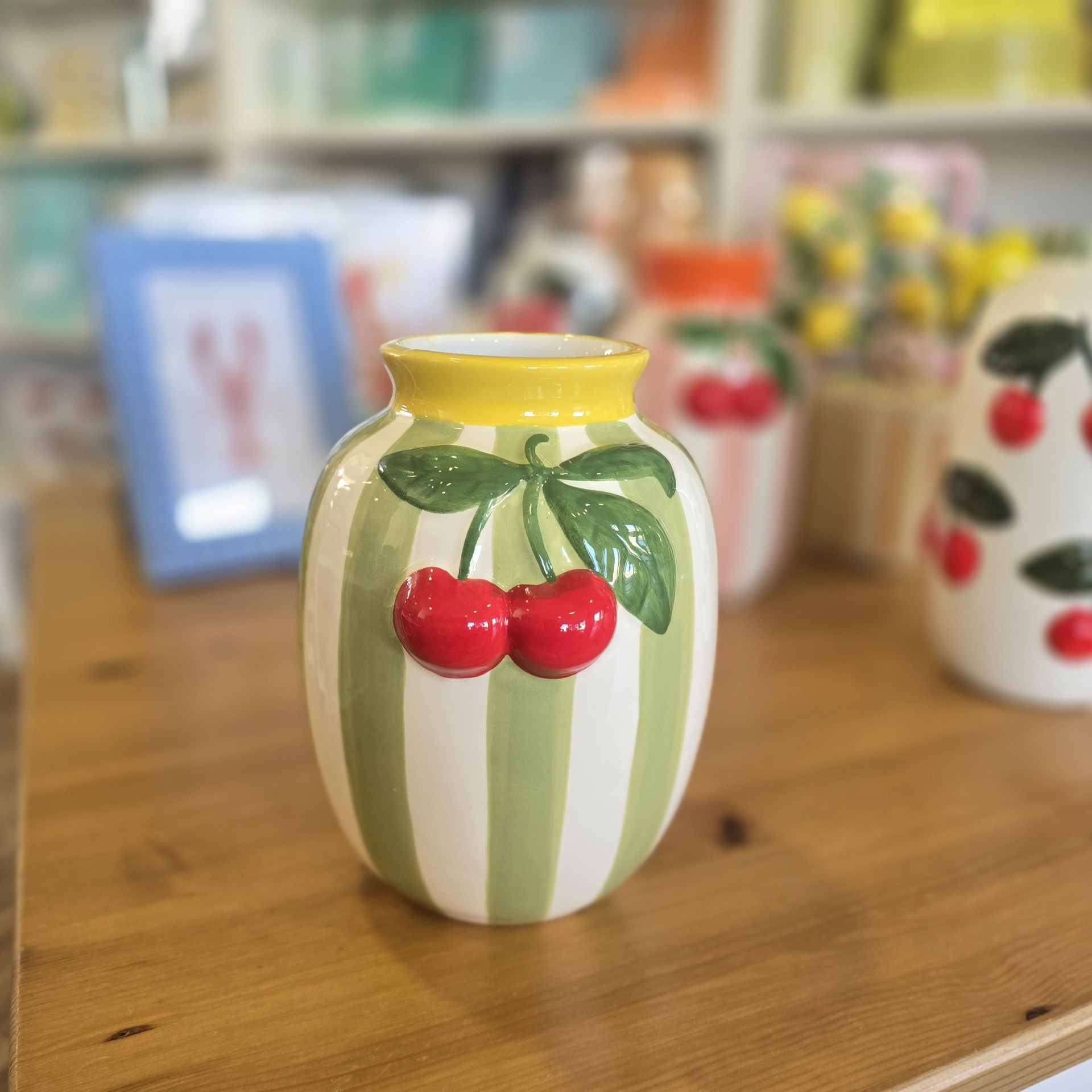Jarro cerâmico verde, branco e amarelo com cerejas em relevo