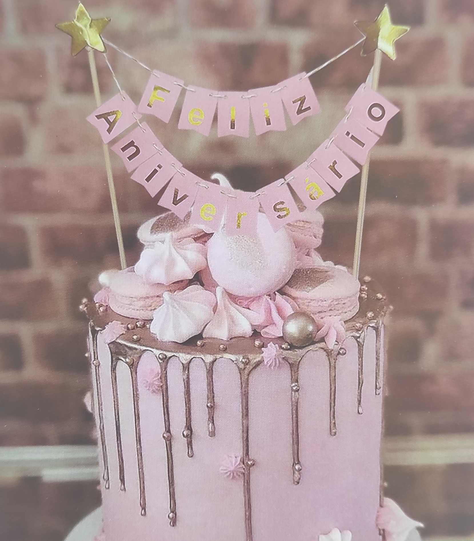 Bolo cor-de-rosa com decoração em chocolate e topos de festa com placa FELIZ ANIVERSÁRIO