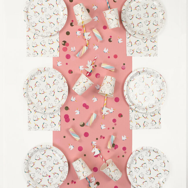 Conjunto de festa com temática de unicórnios em papel sobre mesa rosa