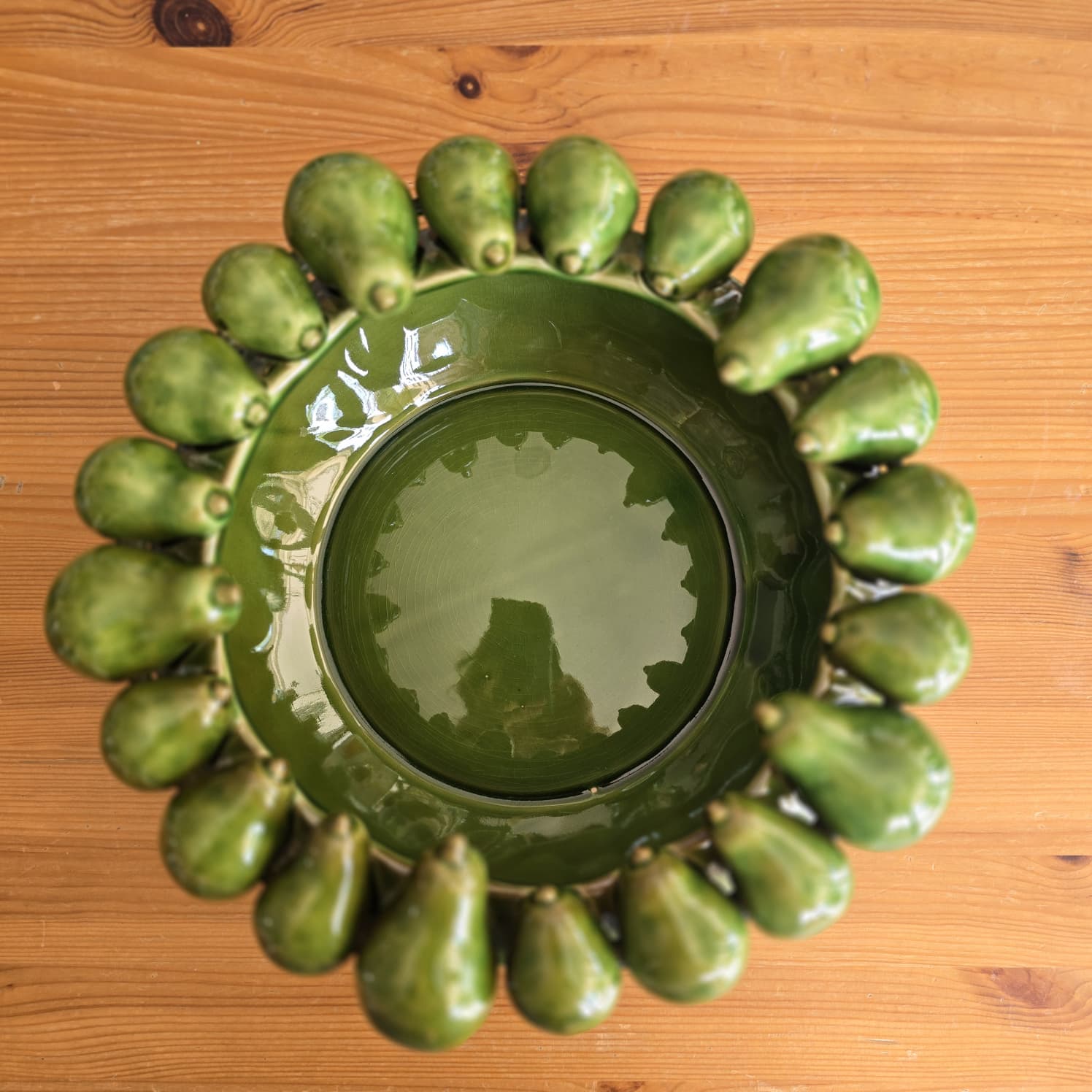Taça ou tigela verde com decoração de pequenas pêras à volta da borda