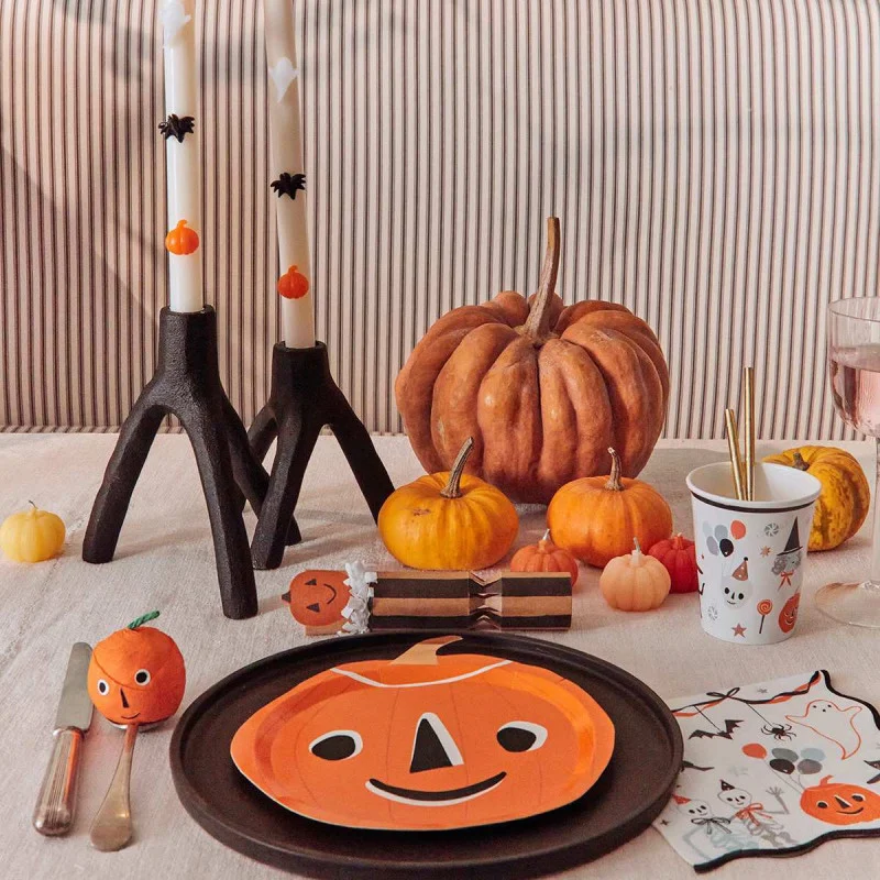 Mesa decorada para Halloween com prato e guardanapos de abóbora, velas, abóboras decorativas e copo temático
