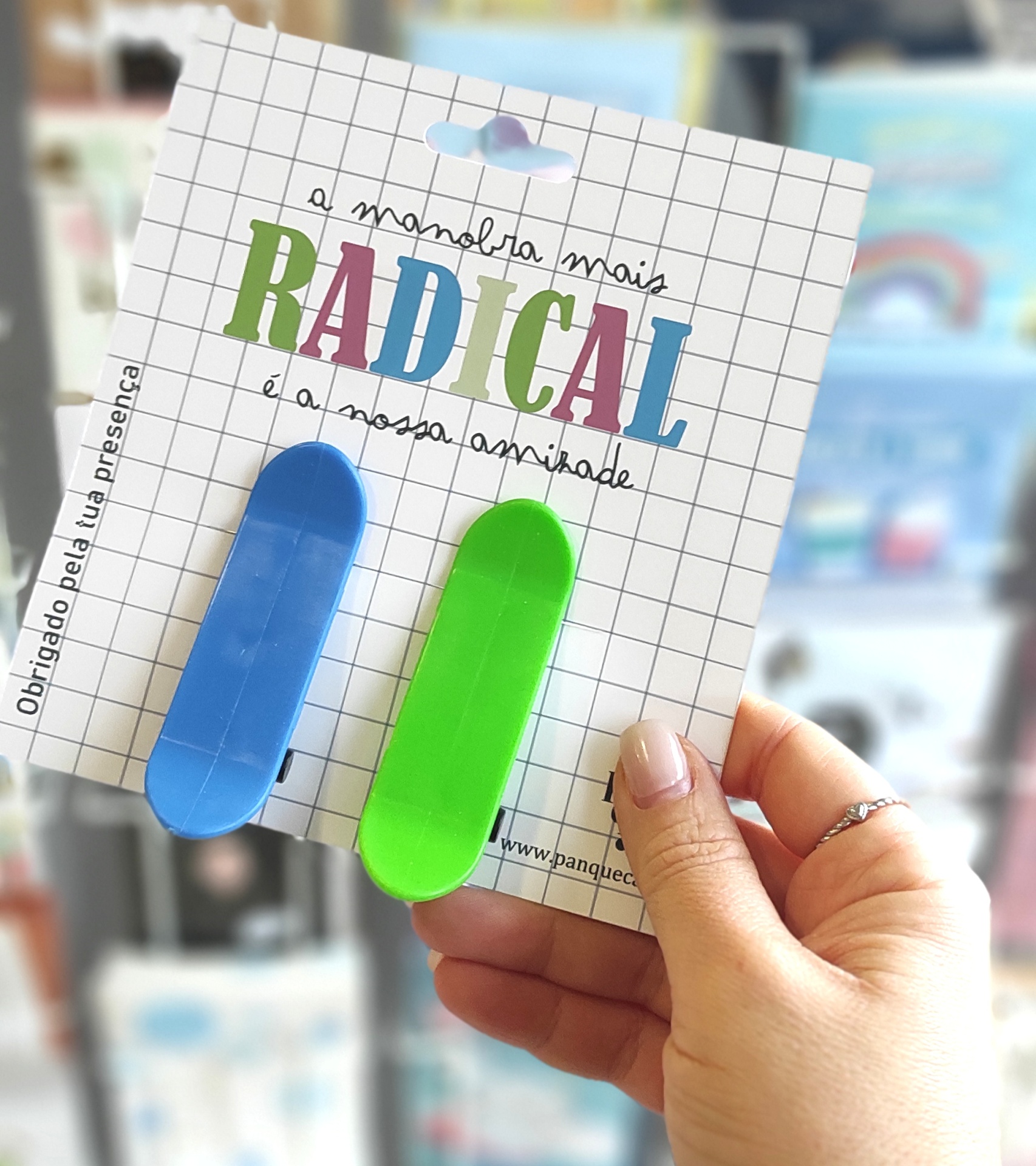 Porta clips coloridos azul e verde em embalagem com texto em padrão de grelha