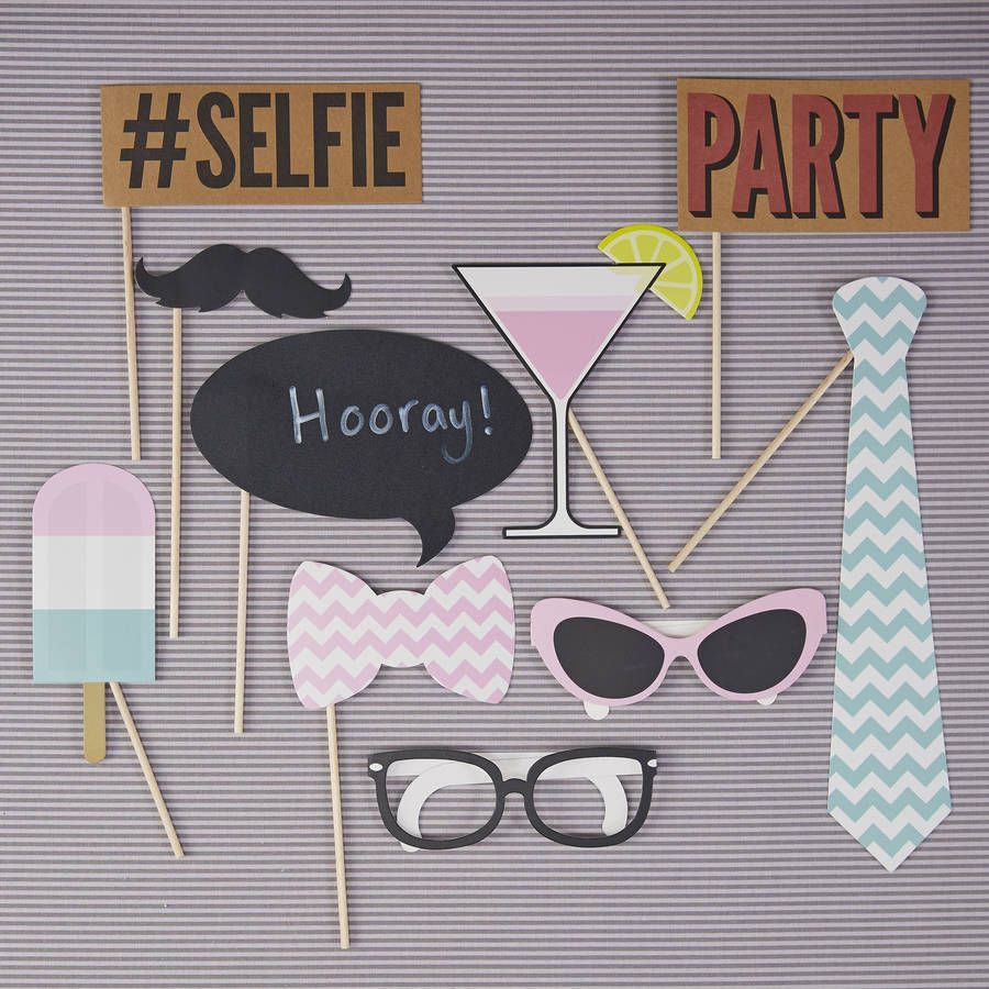 Adereços para festa sobre fundo riscado cinzento com texto #SELFIE, PARTY, Hooray!