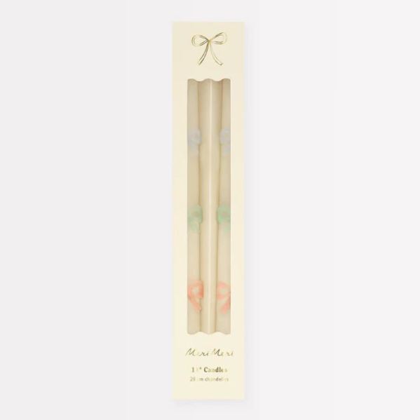 Caixa branca com duas velas finas coloridas e texto Meri Meri