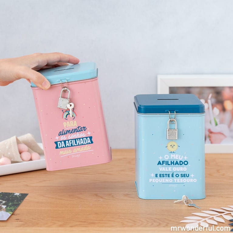 Duas caixas metálicas rosa e azul com texto e cadeado sobre mesa de madeira