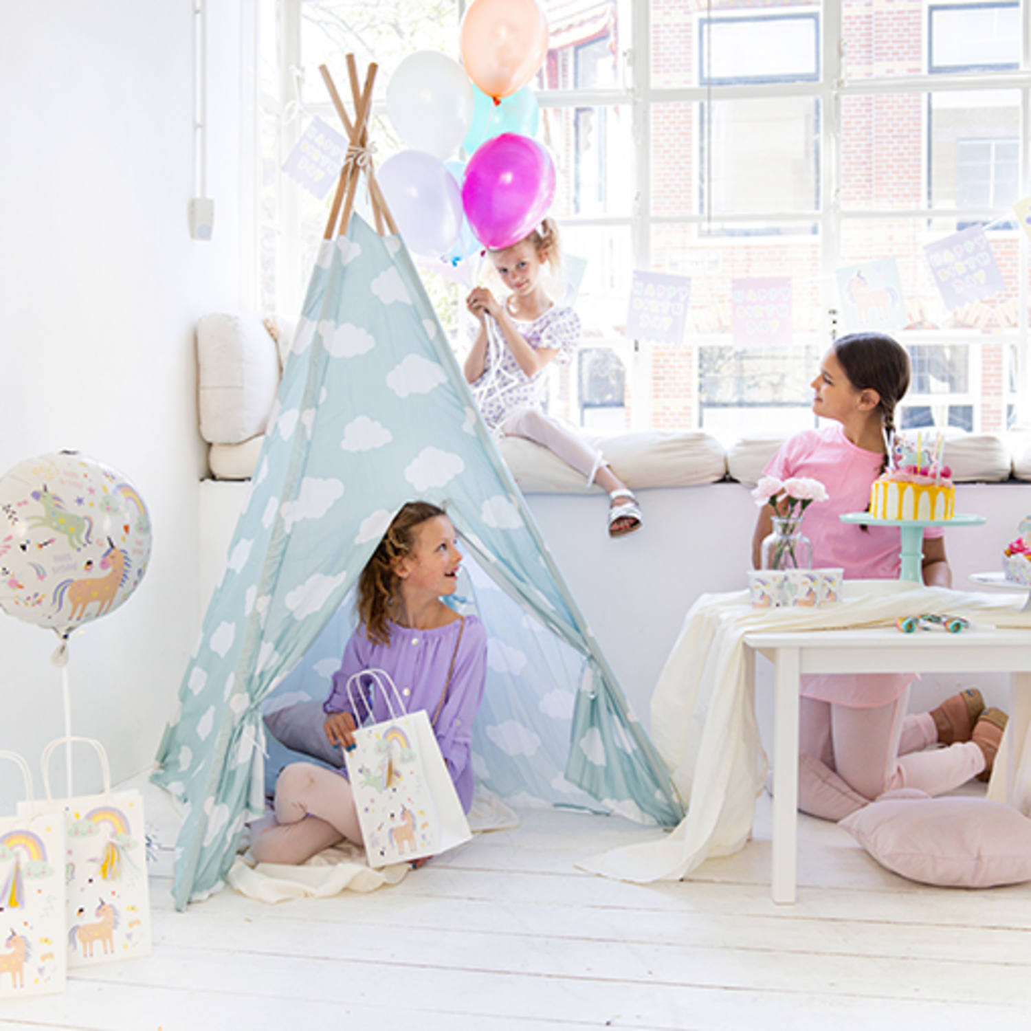 Tenda azul com nuvens e crianças a festejar num ambiente branco e iluminado