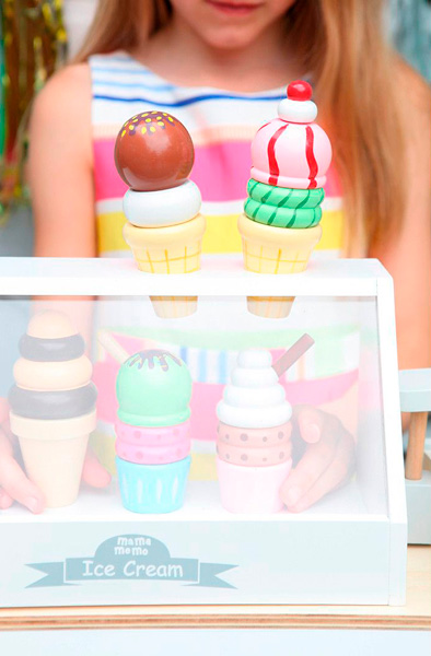 Brinquedo de gelados de madeira coloridos em vitrine branca com criança ao fundo