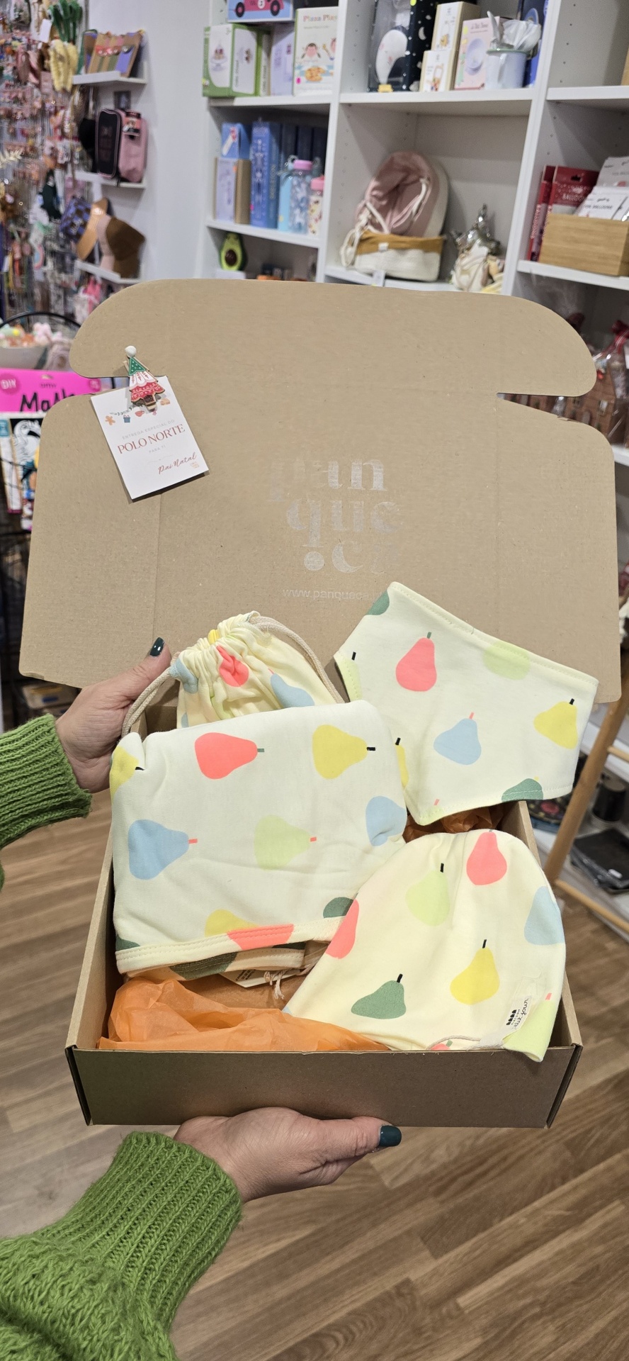 Cachecol, gorro e touca com padrão de pêras coloridas dentro de caixa de cartão aberta