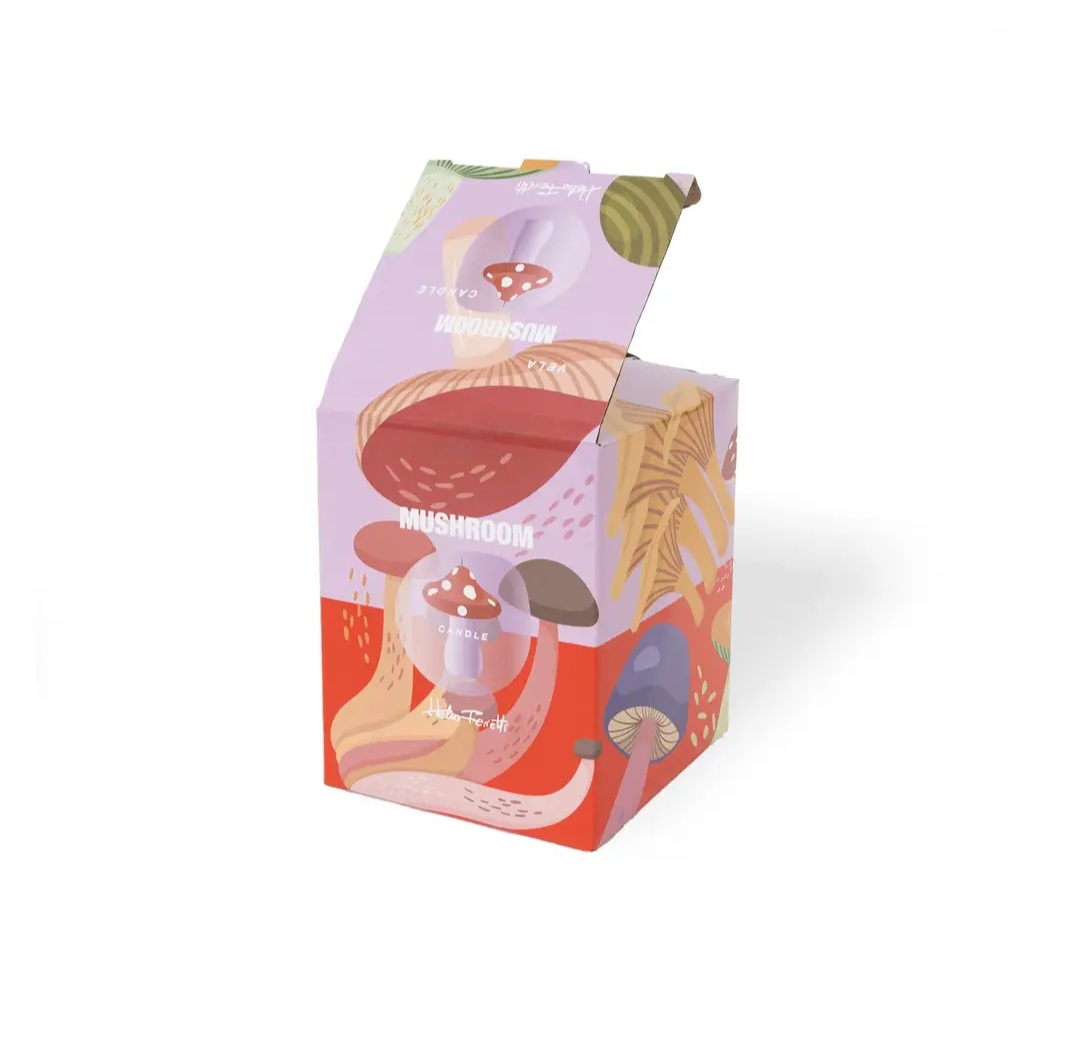 Caixa de embalagem colorida com design de cogumelos e texto MUSHROOM VELA CANDLE