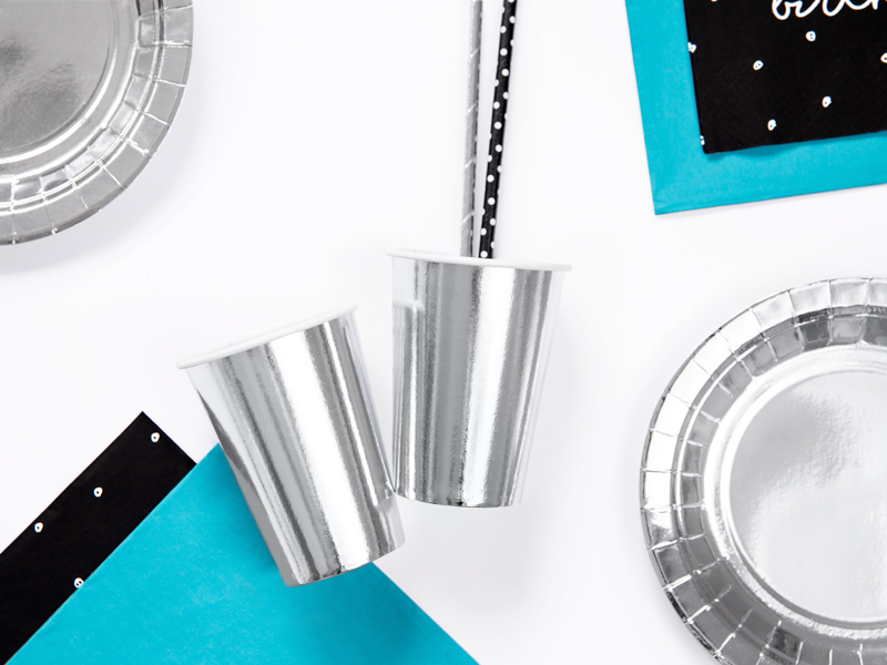 Copos, pratos e guardanapos prateados, azuis e pretos para festa