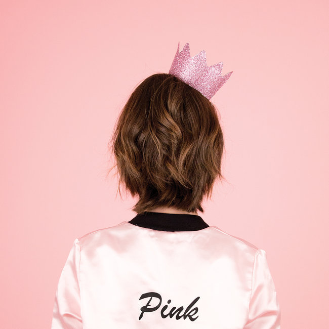 Mulher de costas com coroa cor-de-rosa e casaco rosa com palavra Pink